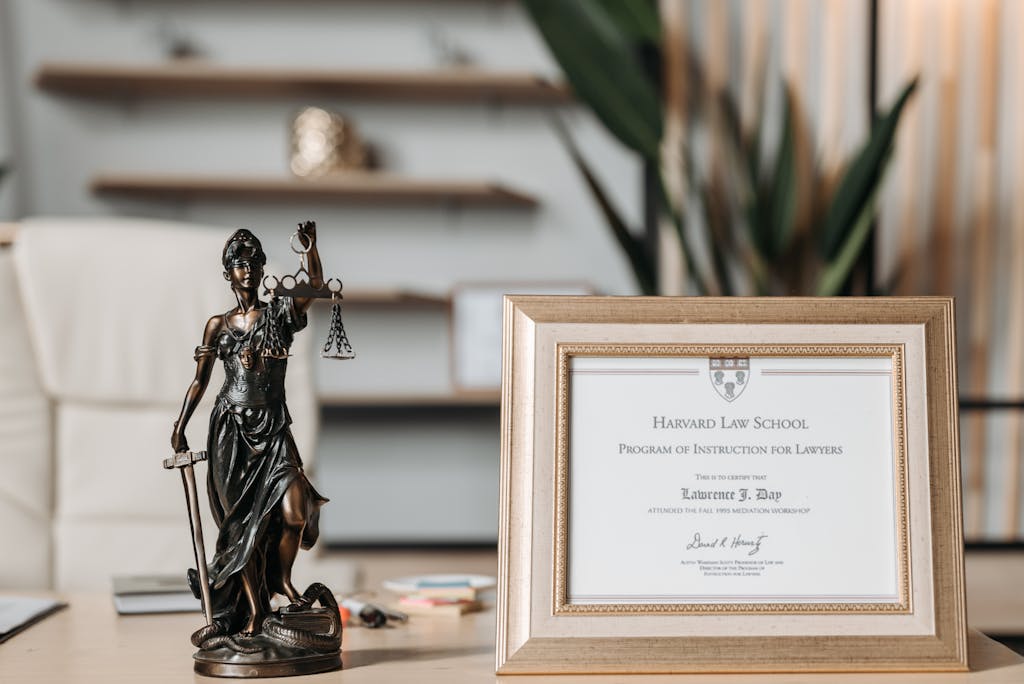 Selectvie Focus Photo of a Lady Justice Statuette and Diploma